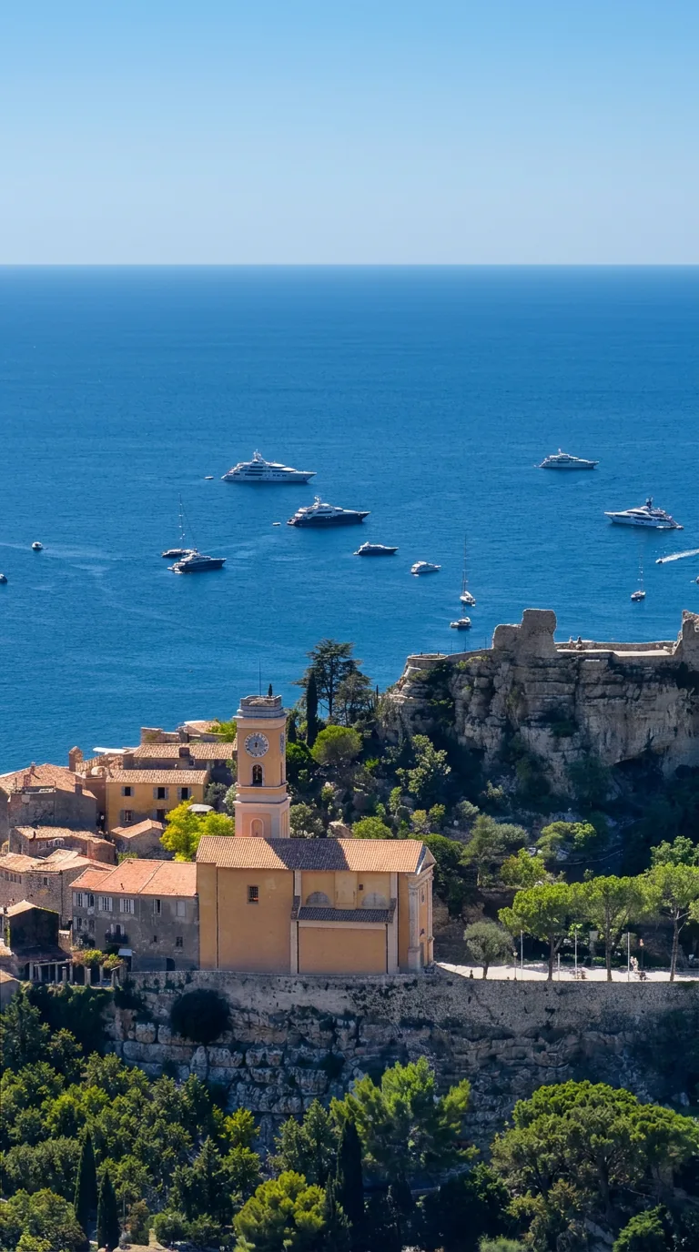 Photo : village perché d'Èze sur son piton rocheux, clocher et ruines du château au sommet, mer Méditerranée en arrière-plan