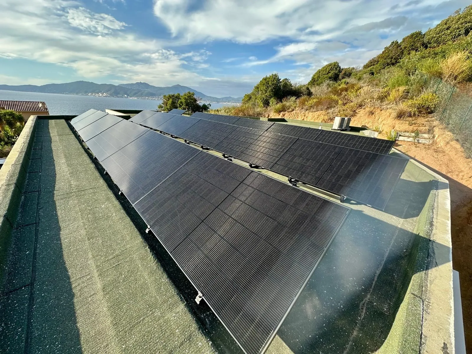 Panneaux solaires sur un toit-terrasse face à la mer