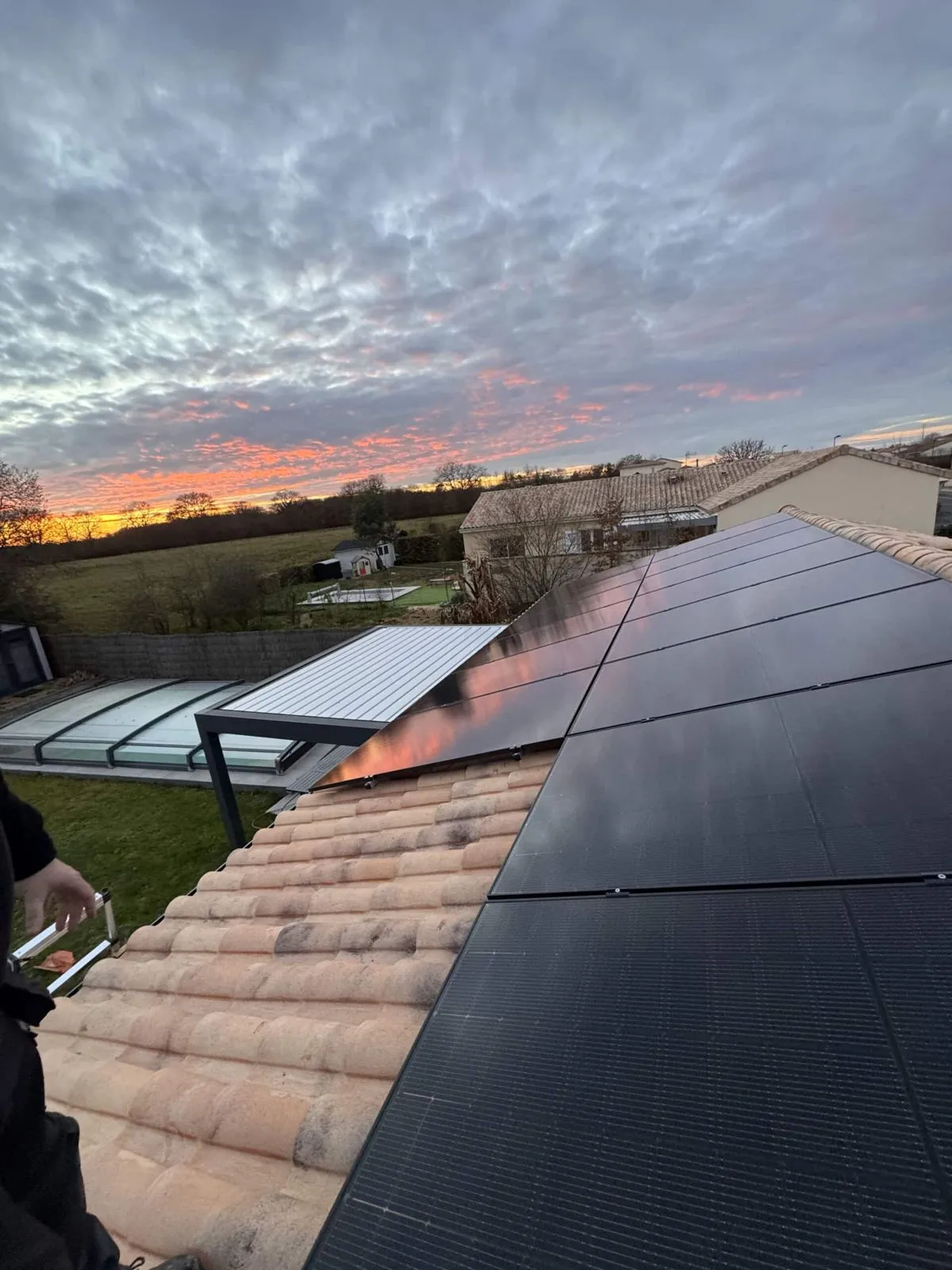 Panneaux solaires sur un toit en tuiles canal au coucher du soleil