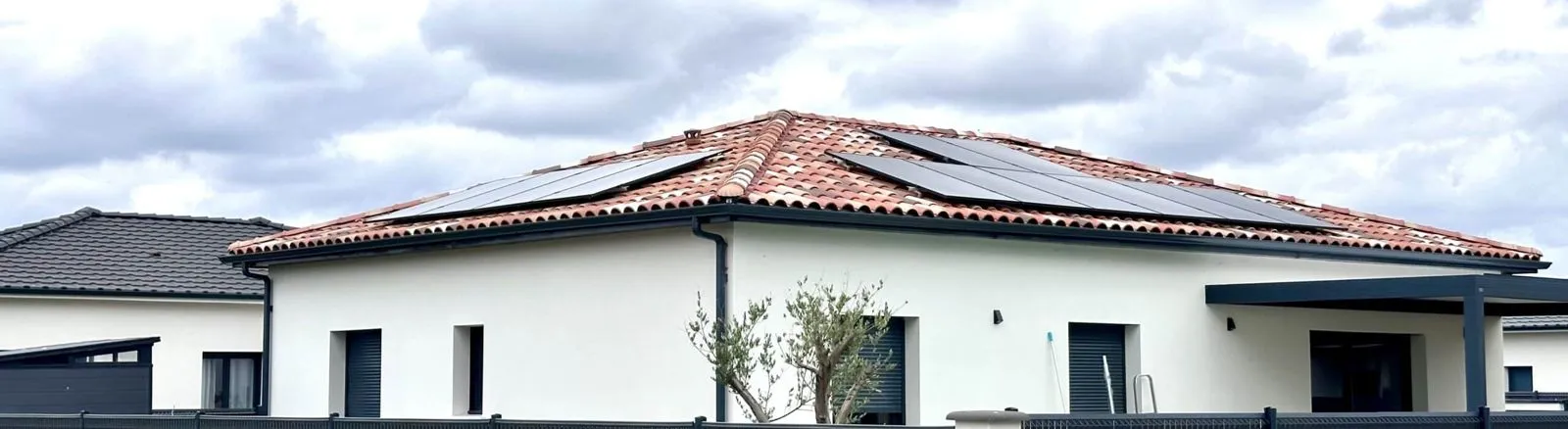 Maison neuve blanche avec panneaux solaires sur le toit en tuiles