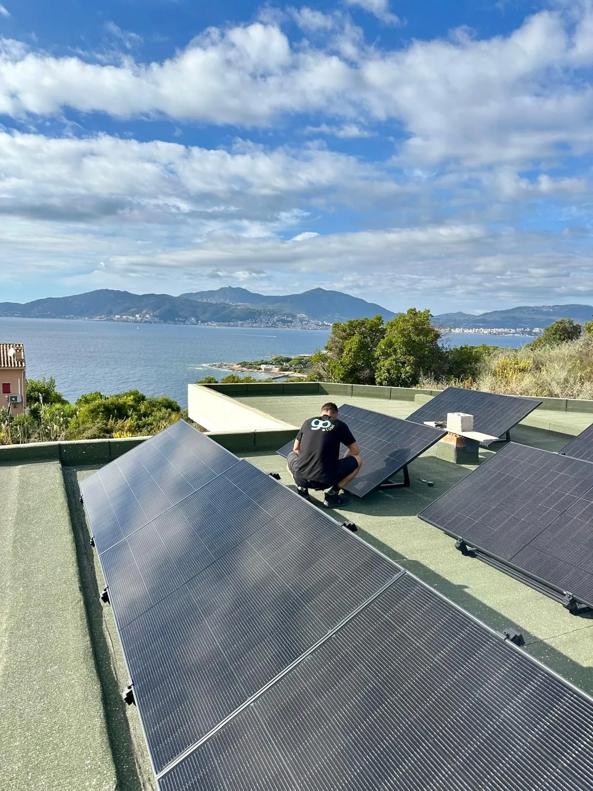 Un technicien GoLumi pose un panneau solaire sur un toit-terrasse