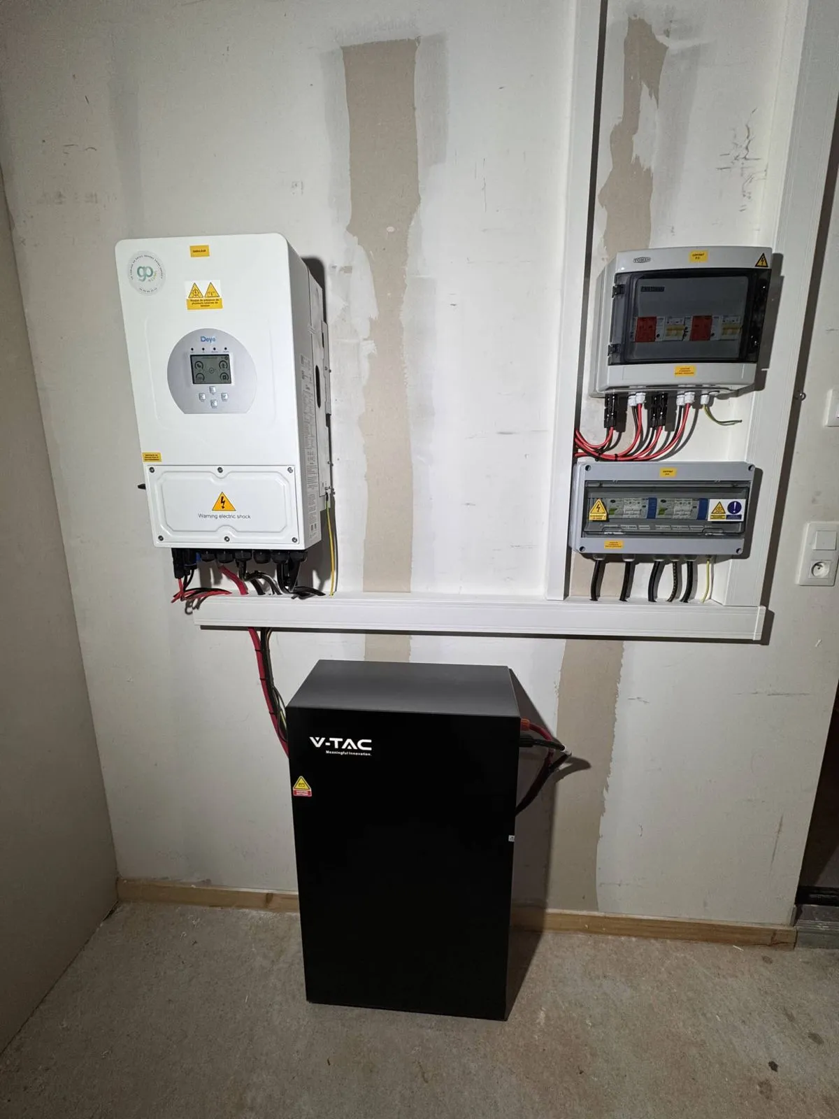 Onduleur hybride blanc et batterie noire dans le local technique