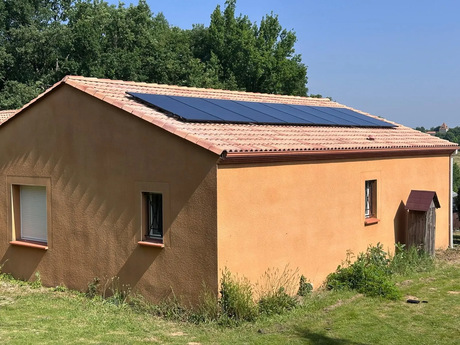 Panneaux solaires noirs posés sur le toit en tuiles de la maison