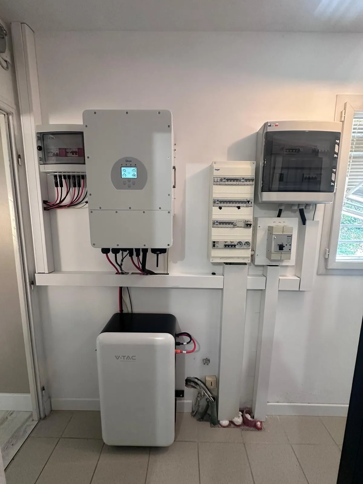 Onduleur hybride et batterie blanche installés dans le local technique